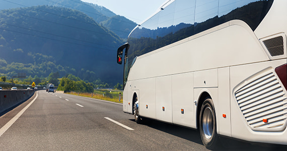 A white charter bus on the open road